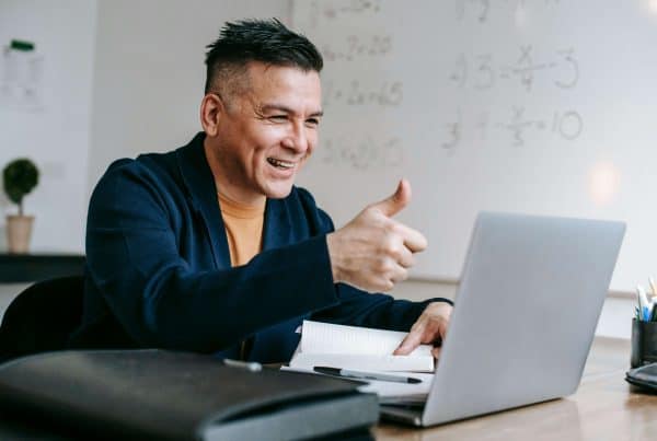 Happy man giving a thumbs-up during online learning or video call.