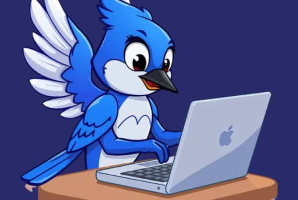 Cartoon blue bird using a laptop, representing digital marketing tools.
